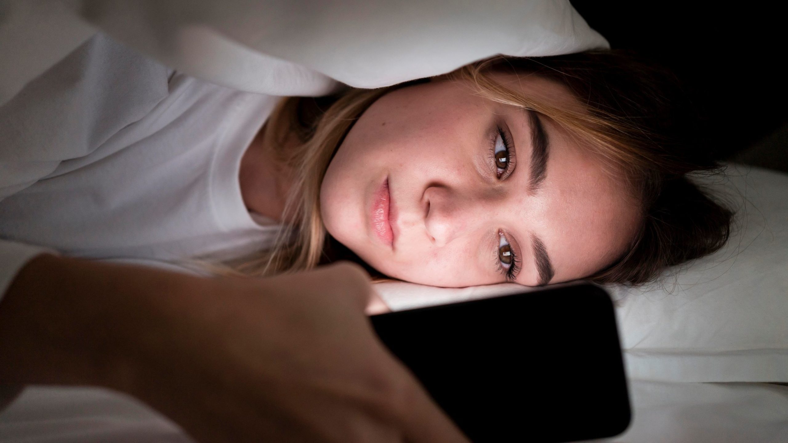 jeune fille la nuit avec une téléphone portable